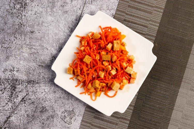 Ensalada con pollo ahumado, zanahoria coreana y picatostes
