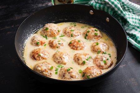 Hähnchenfrikadellen in Sauerrahmsoße in der Pfanne